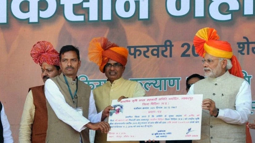 2019 Lok Sabha Election: BJP hopes to reap poll gains from ‘PM Kisan’ in UP Prime Minister Narendra Modi presenting settlement claims of Kharif 2015 crop insurance to a selected beneficiary at Kisan Kalyan Mela in Sehore, Madhya Pradesh