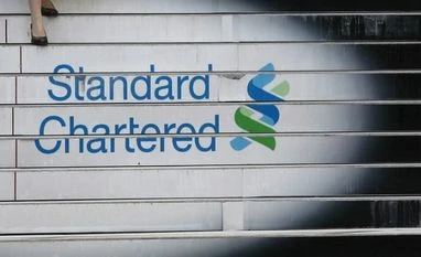 Inter-meeting cut cannot be ruled out: Standard Chartered A woman walks down the stairs of the Standard Chartered headquarters in Hong Kong