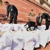 Security persons with a sniffer dog checking Rail Budget documents at Parliament house during the Budget session, in New Delhi