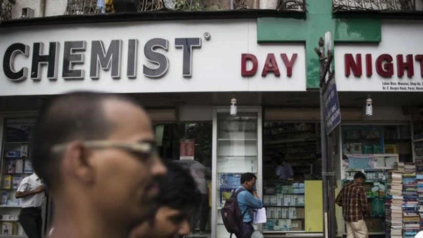 People walk past a chemist shop at a market in Mumbai People walk past a chemist shop at a market in Mumbai