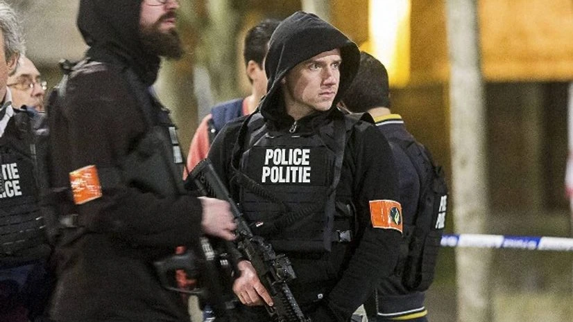Police officers secure an area during an apartment raid in Brussels Police officers secure an area during an apartment raid in Brussels