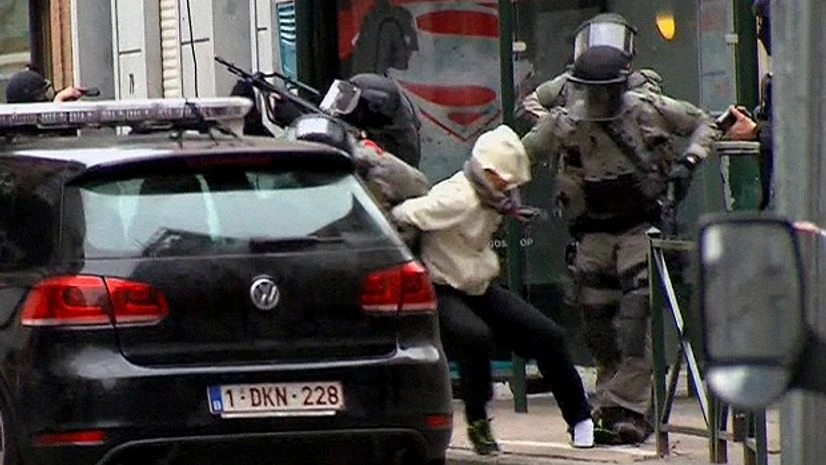 In this framegrab taken from VTM, something appears to drop from inside the trouser leg of Salah Abdeslam, centre, as he is arrested by police and bundled into a police vehicle during a raid in the Molenbeek neighborhood of Brussels, Belgium. In this framegrab taken from VTM, something appears to drop from inside the trouser leg of Salah Abdeslam, centre, as he is arrested by police and bundled into a police vehicle during a raid in the Molenbeek neighborhood of Brussels, Belgium.