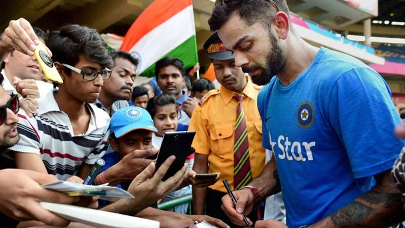 Virat Kohli signs autograph for fans during a training session at Chinnaswamy Stadium in Bengaluru. Photo: PTI Virat Kohli signs autograph for fans during a training session at Chinnaswamy Stadium in Bengaluru. Photo: PTI