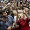 Democratic presidential candidate Hillary Clinton takes photos with supporters in the audience after speaking during a campaign event at Carl Hayden Community High School in Phoenix