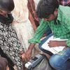 A beneficiary provides her fingerprint for biometric verification at a fair price shop in the Krishna district