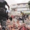 Red Cross members, military and police officers work at a collapsed area after an earthquake struck off Ecuador's Pacific coast on Sunday