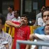 People look at a screen displaying the Sensex on the facade of the Bombay Stock Exchange (BSE) building in Mumbai