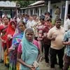 Voters wait in queues to cast votes at a polling station during the final phase of West Bengal Assembly elections in Coochbeahar district