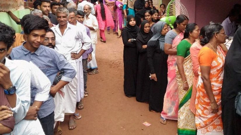 People wait to cast their votes for assembly elections at Puthurmadam in Kozhikode People wait to cast their votes for assembly elections at Puthurmadam in Kozhikode