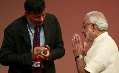 RBI, govt will work to contain inflation at 4%: Narendra Modi Prime Minister Narendra Modi gestures to Reserve Bank of India (RBI) Governor Raghuram Rajan at an event on financial inclusion in Mumbai. Photo: Reuters