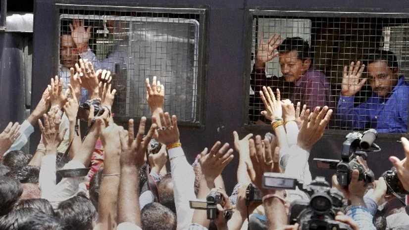 Family member wave to the Gulbarg Society massacre case convicts as they are taken away in van, after the verdict on the case by a special SIT court in Ahmedabad Family member wave to the Gulbarg Society massacre case convicts as they are taken away in van, after the verdict on the case by a special SIT court in Ahmedabad