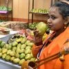An artist smells a mango at the West Bengal Mango festival in New Delhi