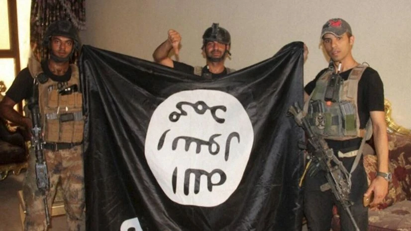 Iraqi soldiers pose with an Islamic State militant flag Iraqi soldiers pose with an Islamic State militant flag