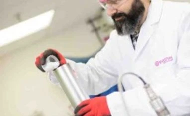 Evonik working on biodegradable composites for medical implants An employee filling in extruder with polymer granulate