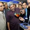Union Defence Minister Manohar Parrikar examines a product as Hindustan Aeronautics Limited MD T Suvarna Raju looks on during the 7th Strategic Electronics Summit 2016 at Bengaluru International Exhibition Centre in Bengaluru