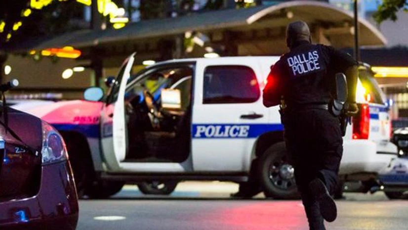 A cop runs towards his police vehicle in Dallas. Photo: Dallas Morning News' Twitter handle A cop runs towards his police vehicle in Dallas. Photo: Dallas Morning News' Twitter handle
