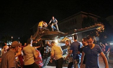 Turkey bans academics from work trips abroad: State media A tank moves into position as Turkish people attempt to stop them in Ankara, Turkey.