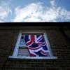 A British flag flutters in front of a window in London