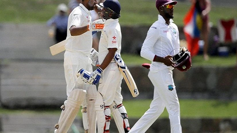 India's Ravichandran Ashwin, left, is embraced by teammate Amit Mishra after scoring a century as West Indie's Jermaine Blackwood walks during day two of their 1st cricket Test match at the Sir Vivian Richards Stadium in North Sound, Antigua. India's Ravichandran Ashwin, left, is embraced by teammate Amit Mishra after scoring a century as West Indie's Jermaine Blackwood walks during day two of their 1st cricket Test match at the Sir Vivian Richards Stadium in North Sound, Antigua.