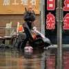 A man sits outside of a flooded shop in Shenyang in northeastern China's Liaoning Province. Dozens of people have been killed and dozens more are missing across China after a round of torrential rains swept through the country.