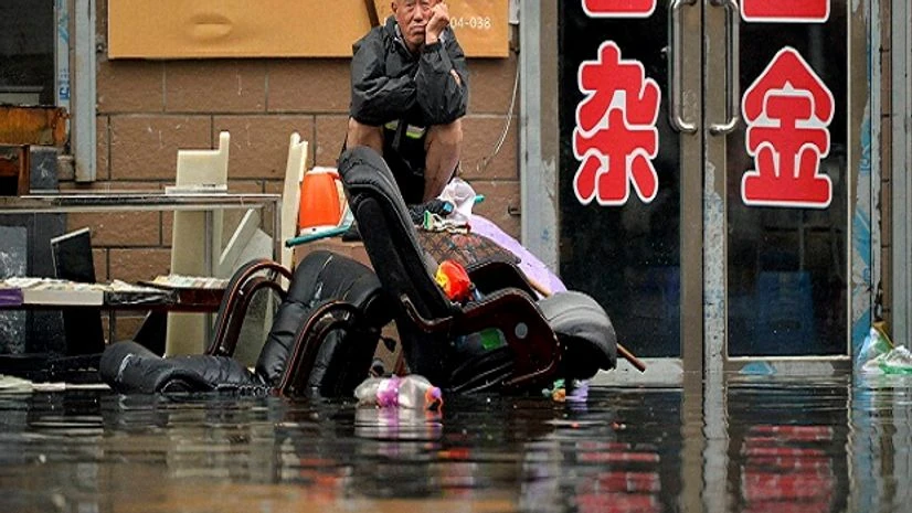 A man sits outside of a flooded shop in Shenyang in northeastern China's Liaoning Province. Dozens of people have been killed and dozens more are missing across China after a round of torrential rains swept through the country. A man sits outside of a flooded shop in Shenyang in northeastern China's Liaoning Province. Dozens of people have been killed and dozens more are missing across China after a round of torrential rains swept through the country.