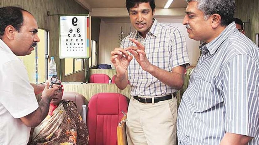 Drishti founder and CEO Kiran Anandampillai (centre) and Nandan Nilekani (right) with a patient inside their mobile van Drishti founder and CEO Kiran Anandampillai (centre) and Nandan Nilekani (right) with a patient inside their mobile van