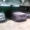 A Rolls Royce covered in sheet enjoys the shade, flanked by a Lexus and a Bentley.