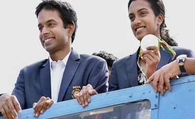 Better coaching for Sindhu, says Telengana minister; gets slammed on Twitter Olympic Silver Medalist P V Sindhu with her Coach Pullela Gopichand flaunts her medal after her arrival at Rajiv Gandhi International Airport in Hyderabad.