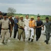 Madhya Pradesh Chief Minister Shivraj Singh Chouhan is carried by security persons to cross the flood water