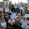 People hold placards and shout slogans during protest against the killing of civilians by security force in Srinagar