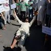 An injured man lies on ground while shouts slogans during protest against the killing of civilians by security forces in Srinagar
