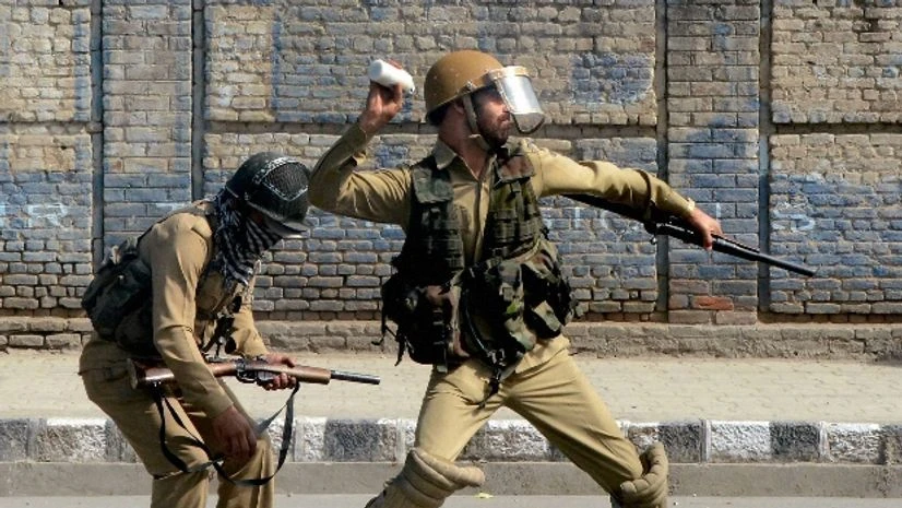 A police man throws a tear gas shell towards protesters to disperse them during clashes in Srinagar A police man throws a tear gas shell towards protesters to disperse them during clashes in Srinagar