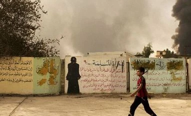 Baghdad: 4 killed, 6 injured in a car bomb attack: Spokesman A young boy walks past partially defaced Islamic State group instructions for muslim women and a written warning to violators of the militant, Iraq