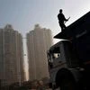 A labourer stands on a truck carrying construction materials at a construction site of residential buildings <b> Reuters <b>