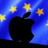 A 3D printed Apple logo is seen in front of a displayed European Union flag