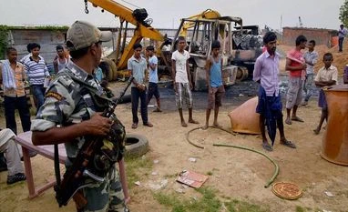 Villagers gather at the construction site where maoists set six construction vehicles on fire, in Gaya district Villagers gather at the construction site where maoists set six construction vehicles on fire, in Gaya district