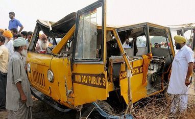 People looking at the damaged school bus that fell in a drain at village Mahwa in Attari. Photo:PTI People looking at the damaged school bus that fell in a drain at village Mahwa in Attari. Photo:PTI