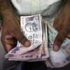 A private money trader counts rupees at a shop in Mumbai. Photo:Reuters