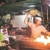 A vendor barbeques satay at a food court in Singapore. The city state is increasingly turning to machines to replace low-end manpower. Bloomberg