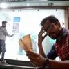 A man sits with Rupees 500 currency notes withdrawn from an ATM  after PM Narendra Modi announced to cease Rupees 500 and 1000 currency notes, in Bhopal