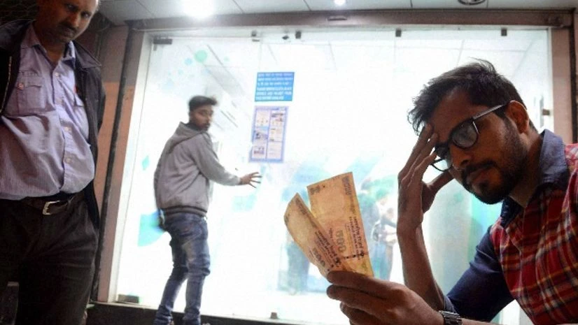 A man sits with Rupees 500 currency notes withdrawn from an ATM after PM Narendra Modi announced to cease Rupees 500 and 1000 currency notes, in Bhopal A man sits with Rupees 500 currency notes withdrawn from an ATM after PM Narendra Modi announced to cease Rupees 500 and 1000 currency notes, in Bhopal