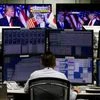 Employee of a foreign exchange trading company works near monitors showing US President-elect Donald Trump speaking on TV news in Tokyo (Reuters)