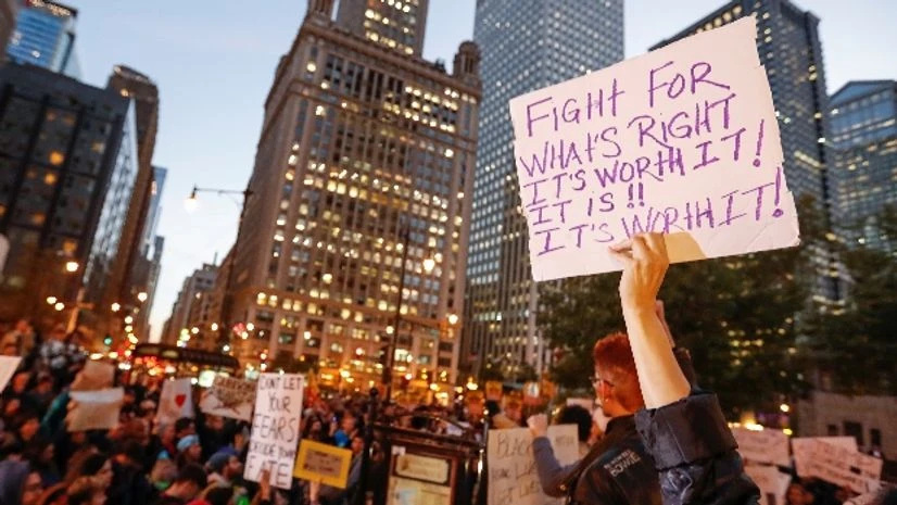 A protester holds a sign during a protest against Republican president-elect Donald Trump outside Trump International Hotel and Tower in Chicago, Illinois A protester holds a sign during a protest against Republican president-elect Donald Trump outside Trump International Hotel and Tower in Chicago, Illinois