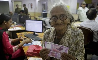 India's crackdown on black money will help financial system:EU An eighty five years old woman displays the new Rupees 2000 currency notes she received at a bank in Allahabad