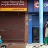Women wait for ATM counters to open in Jammu