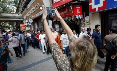 Mumbai among trending tourist spots for 2017 A foreign tourist takes pictures of people standing in a queue outside a bank to exchange and deposit their old, high denomination banknotes in Kolkata