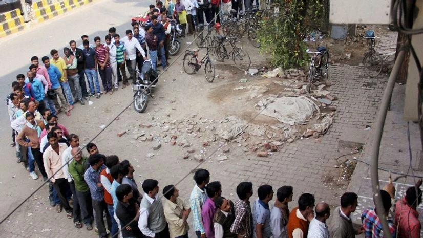 People stand in a long queue outside an ATM to withdraw money in Gurugram on Sunday People stand in a long queue outside an ATM to withdraw money in Gurugram on Sunday