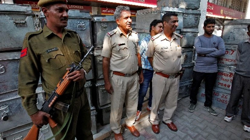 Policemen stand guard in front of boxes carrying Indian rupee banknotes outside a bank in Chandigarh Policemen stand guard in front of boxes carrying Indian rupee banknotes outside a bank in Chandigarh