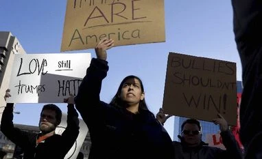 Undocumented Indian immigrants in US hold $15.5 billion in spending power Protesters hold signs as they march in opposition to the election of President-elect Donald Trump