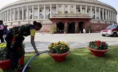 Govt to print plastic currency notes to prevent counterfeiting A gardner waters flower pots at Parliament House during the Winter Session, in New Delhi. Photo: PTI